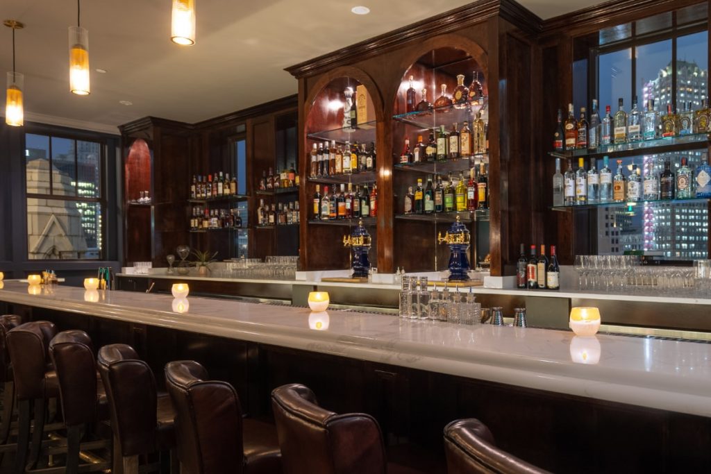 The long bar at The Monarch Club, one of the best cocktail bars in downtown Detroit, showing off its wide selection of spirits.