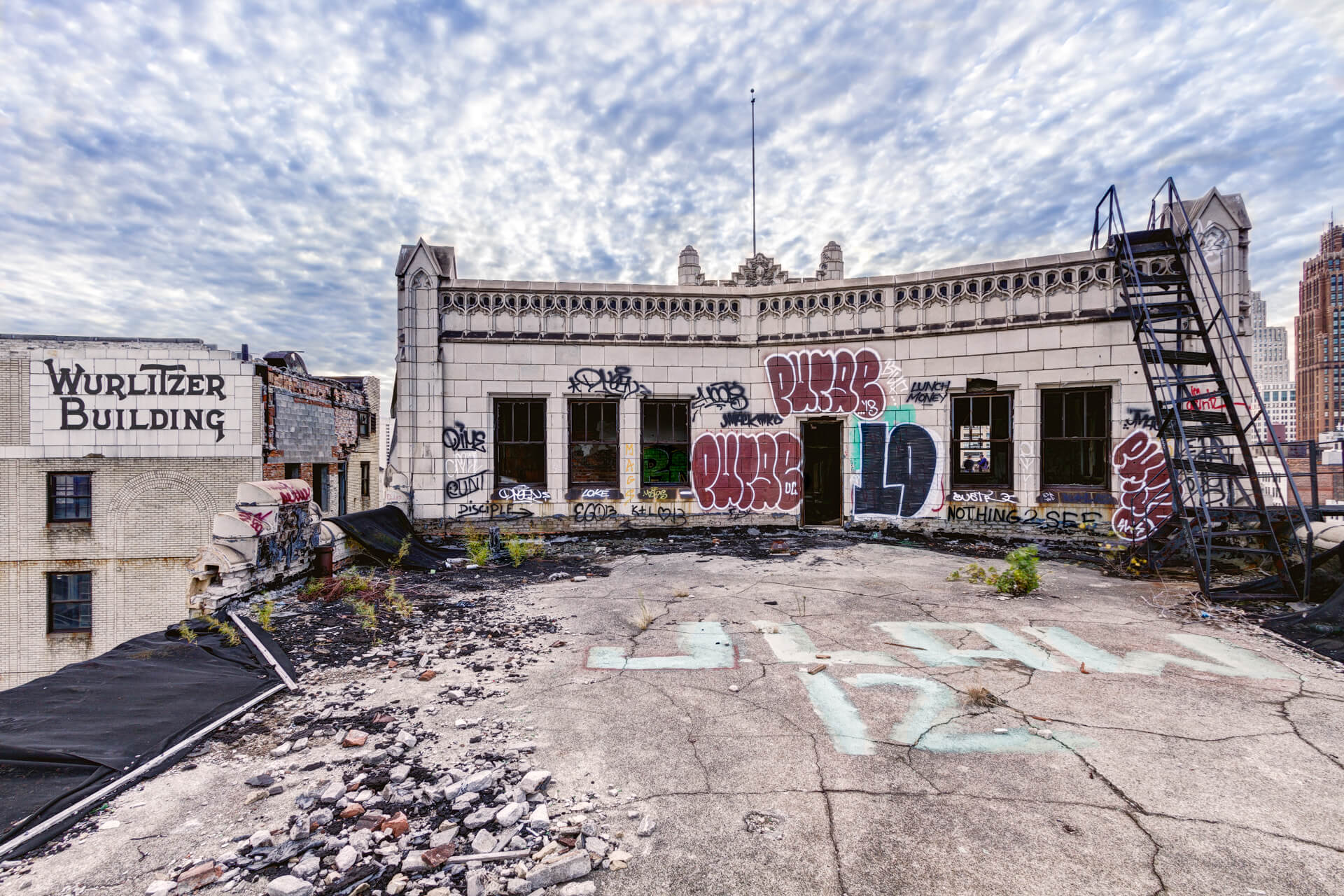 The patio at The Monarch Club before construction has extensive damage, broken stone, and graffiti.
