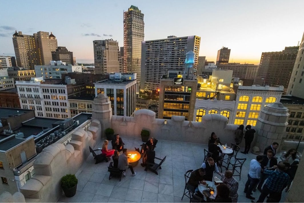 The exterior patio with parapet walls and views of the downtown skyline.